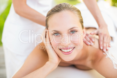 Beautiful woman receiving stone massage at spa center