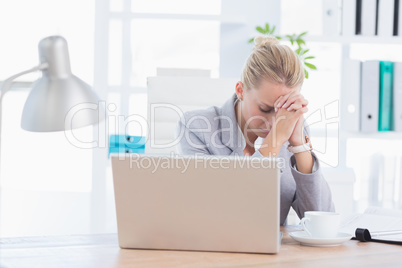 Frustrated businesswoman with head in hands