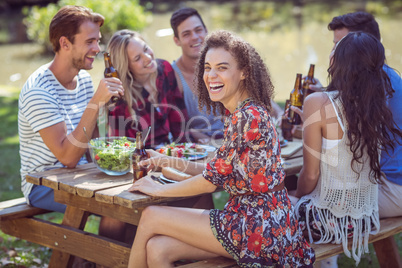 Happy friends in the park having lunch