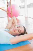 Smiling woman lying on exercise mat