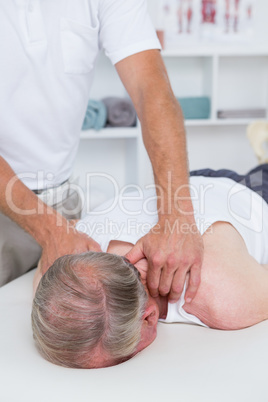 Physiotherapist doing shoulder massage to his patient