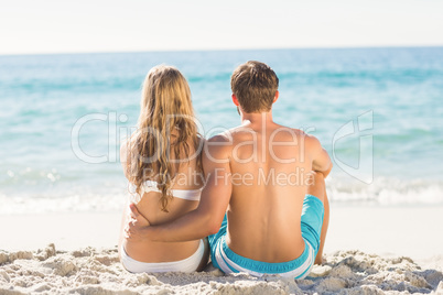 Happy couple relaxing together in the sand