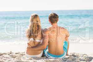 Happy couple relaxing together in the sand