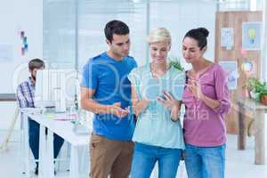 Three casual colleagues using digital tablet