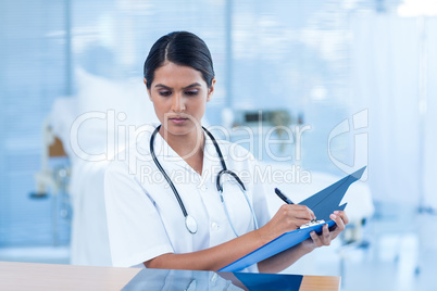 Beautiful doctor analyzing xray and taking notes