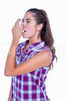Pretty brunette woman using asthma inhaler