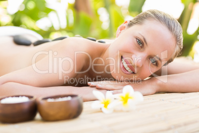 Beautiful woman receiving stone massage at spa center