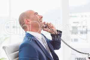 Happy businessman on the phone laughing
