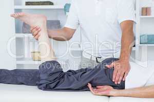 Physiotherapist doing leg massage to his patient