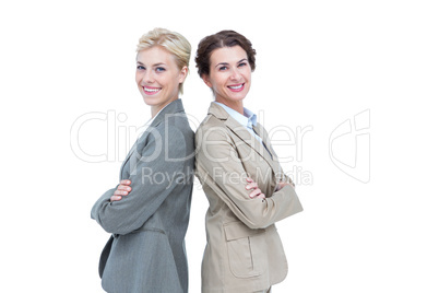 Serious businesswomen standing back on back