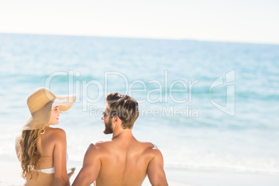 Happy couple relaxing together in the sand