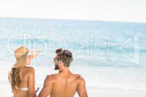 Happy couple relaxing together in the sand