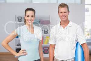 Smiling woman with her trainer looking at camera