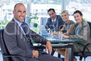 Businessman with his colleagues behind