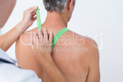 Doctor examining her patient shoulder