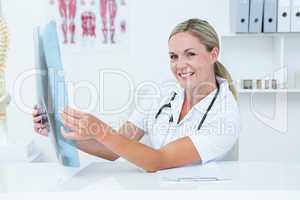 Smiling doctor looking at camera and holding X-Rays