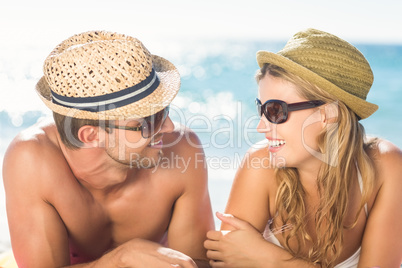 Happy couple relaxing together in the sand