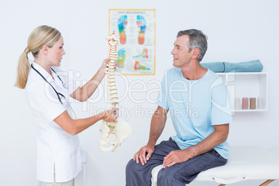 Doctor showing anatomical spine to her patient