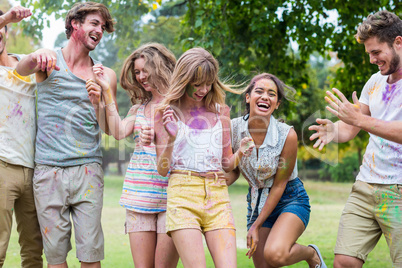 Happy friends throwing powder paint