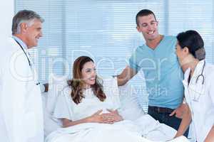 Future parents talking with smiling doctors
