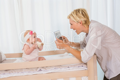 Happy mother taking a picture of her baby girl