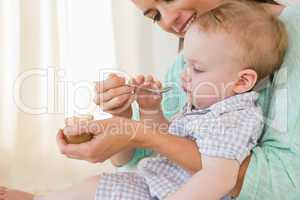 Happy mother eating with her baby boy