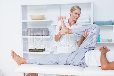 Physiotherapist doing leg massage to her patient