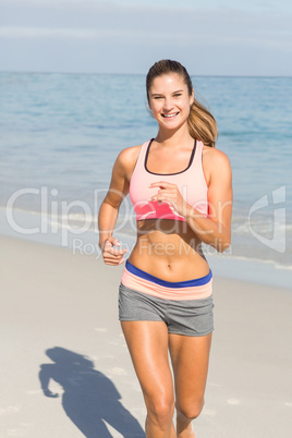 Beautiful fit woman running on beach