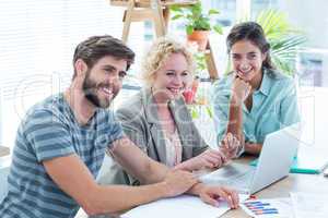 Colleagues using laptop at office