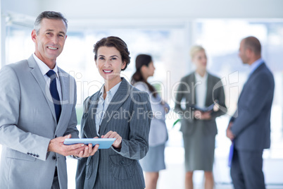 Businesswoman showing the tablet and smiling at the camera