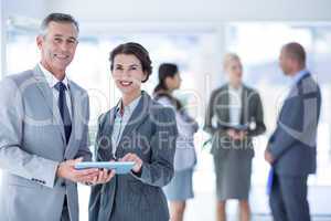 Businesswoman showing the tablet and smiling at the camera
