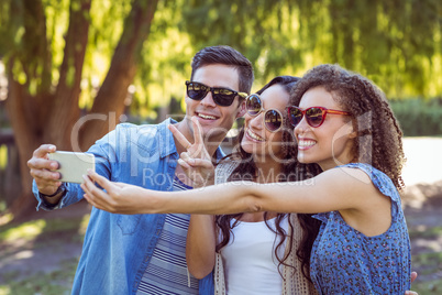 Happy friends taking a selfie in the park