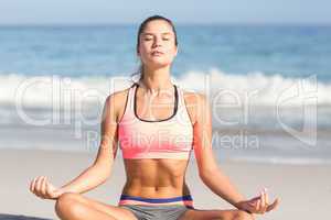 Fit woman doing yoga beside the sea