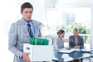 Businessman carrying his belongings in box