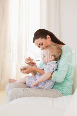 Happy mother eating with her baby boy