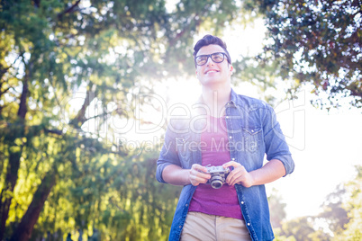 Handsome hipster holding vintage camera