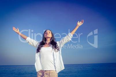 Happy woman with eyes closed at the beach