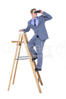 A businessman using binoculars while climbing on a ladder