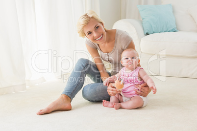 Happy mother playing with her baby girl