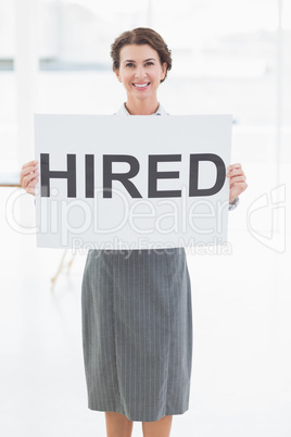 Businesswoman holding sign in front of her