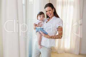 Happy mother with her cute baby girl using tablet