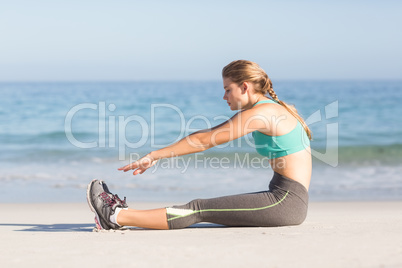 Fit woman stretching beside the sea