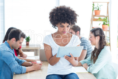 Colleagues using laptop and tablet in office