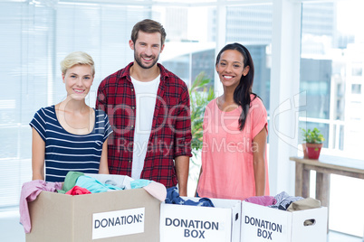 Smiling young friends volunteers separating clothes