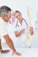 Doctor showing her patient a spine model