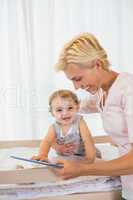 Smiling blonde woman with his son using digital tablet