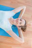 Smiling woman lying on exercise mat