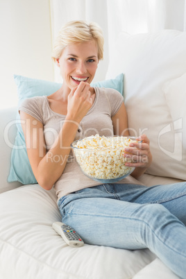 Portrait smiling blonde woman eating pop corn