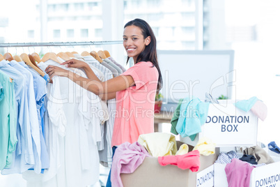 Smiling young female volunteer separating clothes
