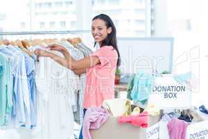 Smiling young female volunteer separating clothes